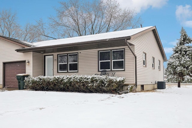 view of front of home with an attached garage and central air condition unit