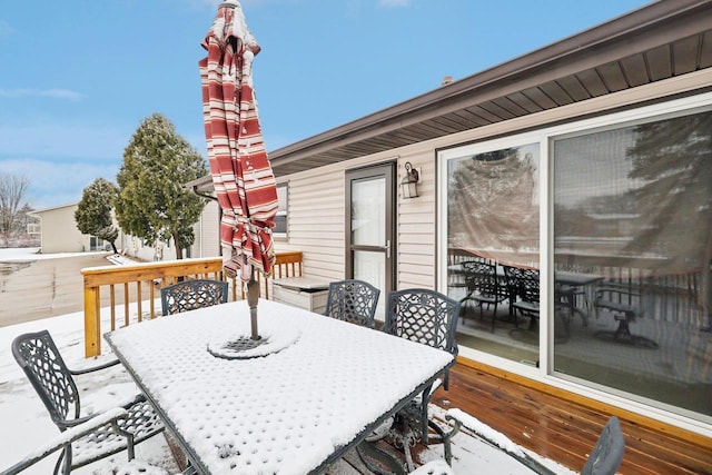 snow covered deck with outdoor dining area