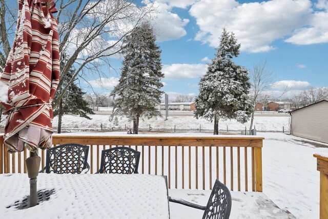 snow covered deck featuring outdoor dining space