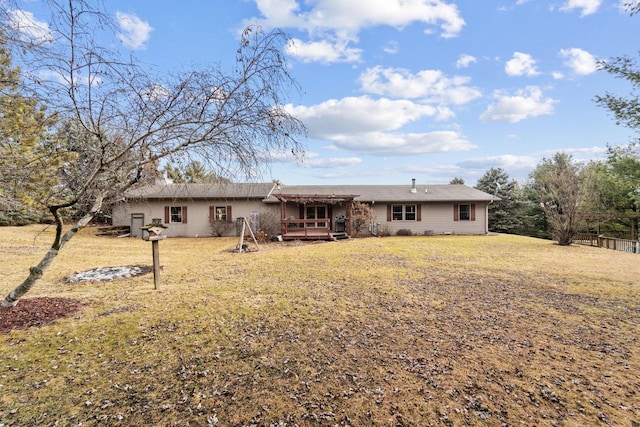 rear view of property featuring a wooden deck and a yard