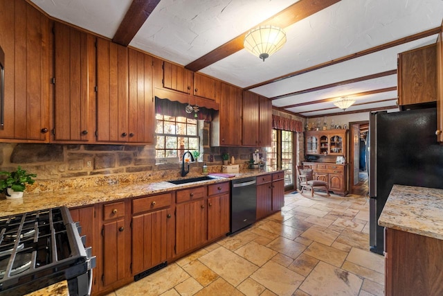 kitchen with plenty of natural light, dishwashing machine, gas range, freestanding refrigerator, and a sink