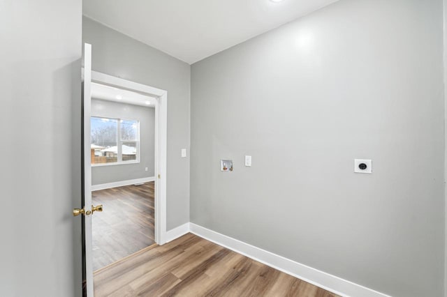 laundry room with hookup for a washing machine, electric dryer hookup, wood finished floors, laundry area, and baseboards