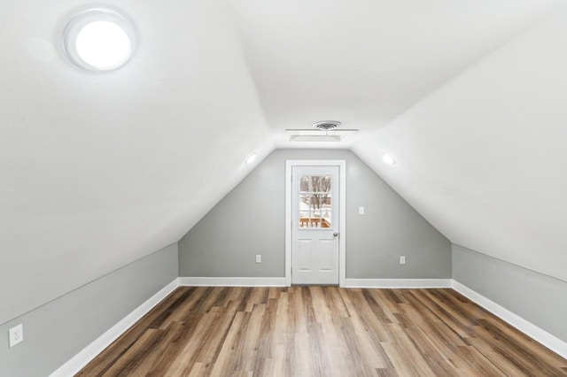 bonus room featuring lofted ceiling, baseboards, and wood finished floors