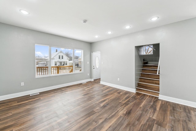 unfurnished living room featuring recessed lighting, visible vents, stairway, wood finished floors, and baseboards