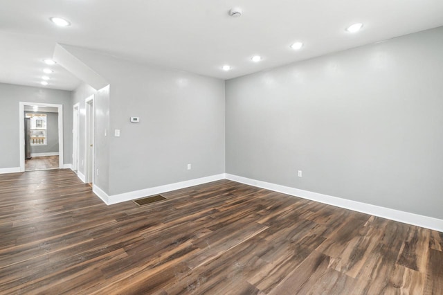spare room with baseboards, visible vents, dark wood finished floors, and recessed lighting