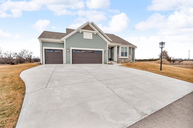 view of front facade with driveway, roof with shingles, and a front yard