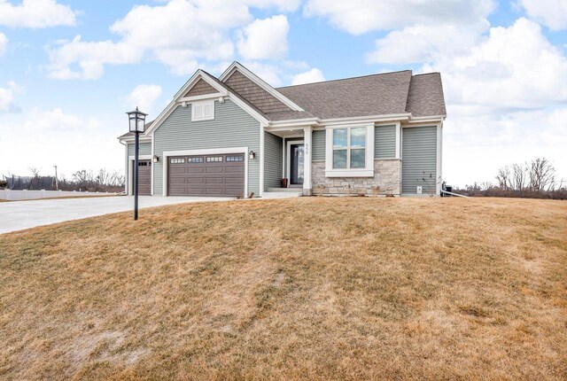 view of front of home featuring driveway, a front lawn, stone siding, and a shingled roof