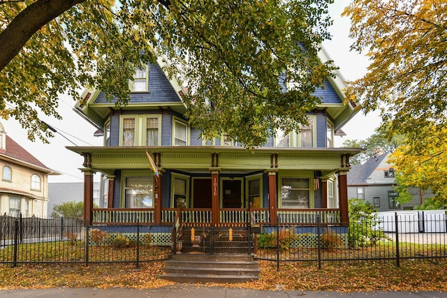 victorian home featuring a porch and fence