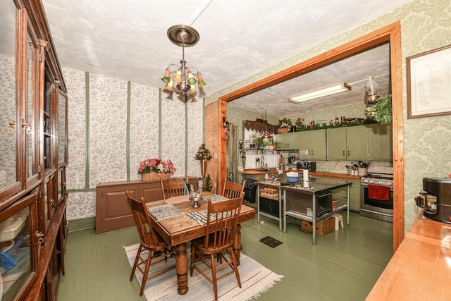 dining area with wood finished floors, a notable chandelier, and wallpapered walls