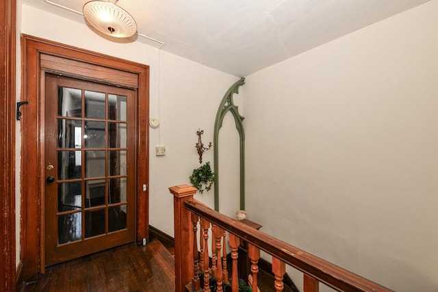 corridor with an upstairs landing and hardwood / wood-style flooring