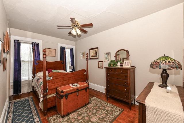 bedroom with baseboards, a ceiling fan, and dark wood-style flooring