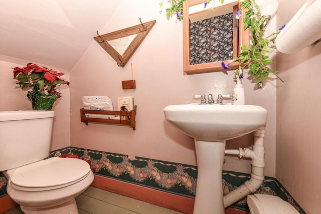 bathroom featuring lofted ceiling and toilet