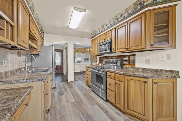 kitchen with dark countertops, light wood-style flooring, appliances with stainless steel finishes, open shelves, and backsplash