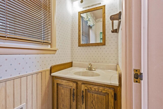 bathroom with a baseboard radiator, a wainscoted wall, vanity, and wallpapered walls