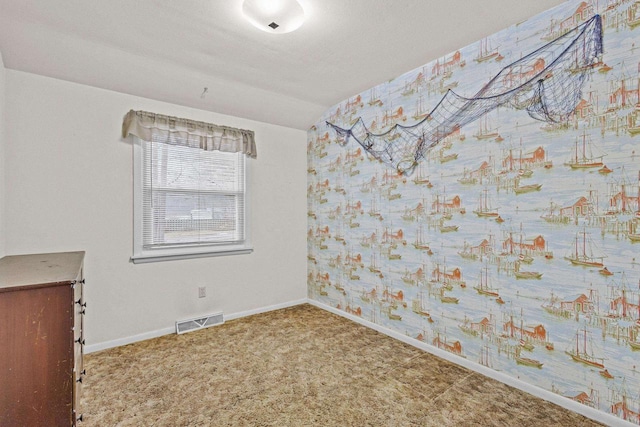 carpeted empty room featuring visible vents, baseboards, and wallpapered walls