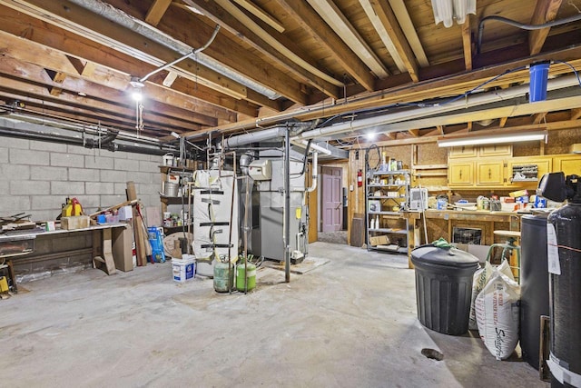 unfinished basement featuring concrete block wall and a workshop area