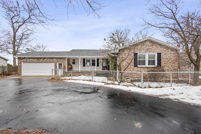 view of front of home featuring a garage, driveway, brick siding, and a fenced front yard