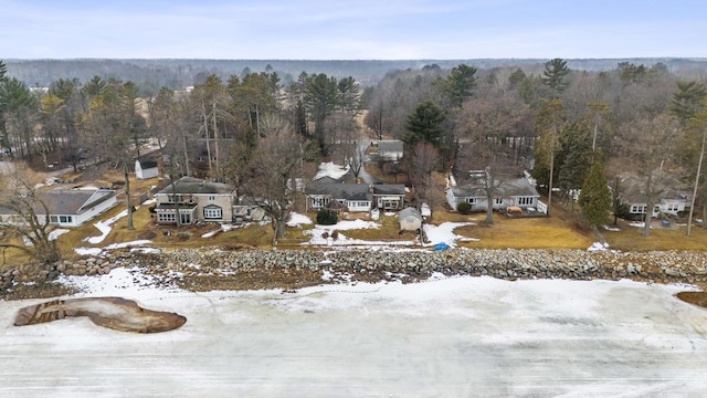 snowy aerial view featuring a forest view