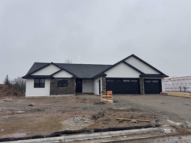 view of front of house with a garage and dirt driveway