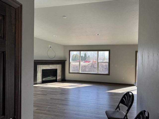 unfurnished living room featuring wood finished floors, a fireplace, and baseboards