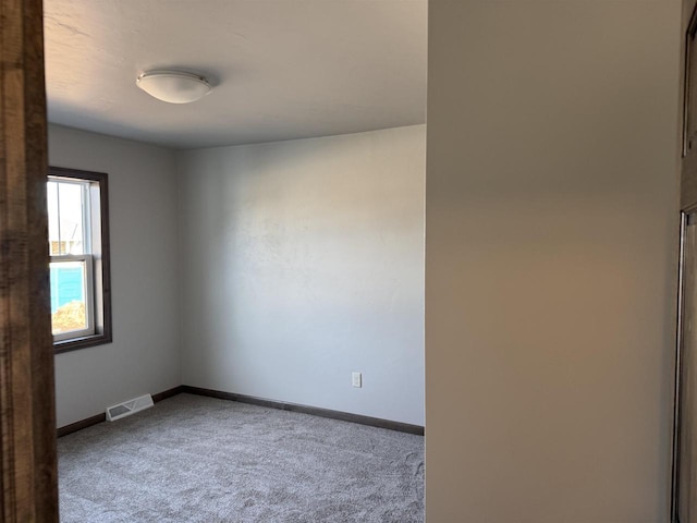 spare room with baseboards, visible vents, and carpet floors