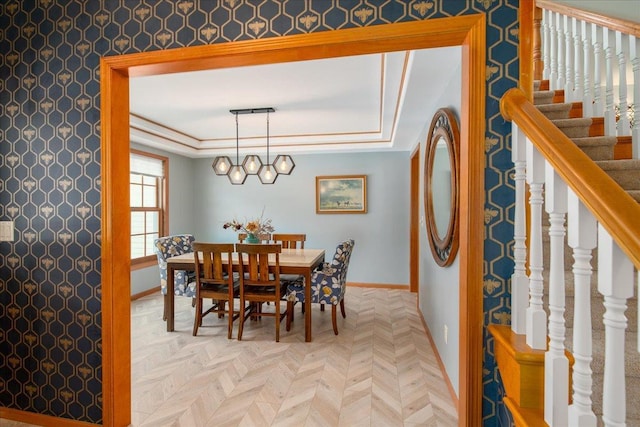 dining area featuring a tray ceiling, baseboards, and stairs