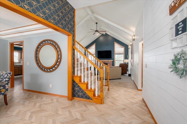 staircase featuring ceiling fan, lofted ceiling with beams, and baseboards