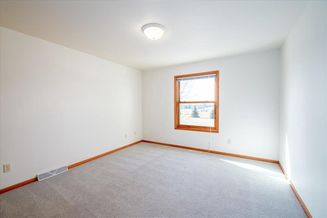 empty room with light carpet, baseboards, and visible vents