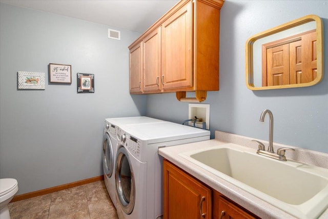 clothes washing area featuring laundry area, baseboards, visible vents, washer and dryer, and a sink