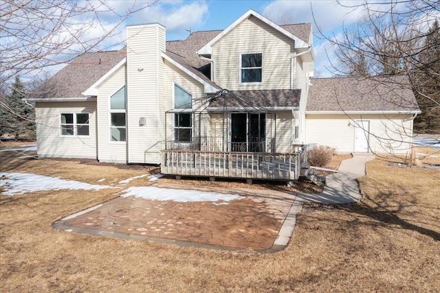 back of house with a deck, a patio, and a shingled roof