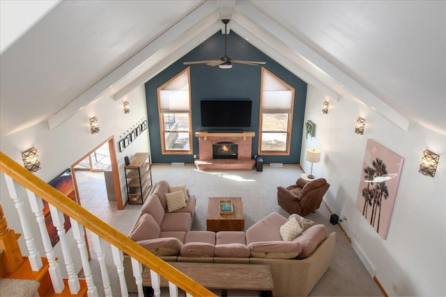 living area with vaulted ceiling with beams, a fireplace, a ceiling fan, baseboards, and stairway