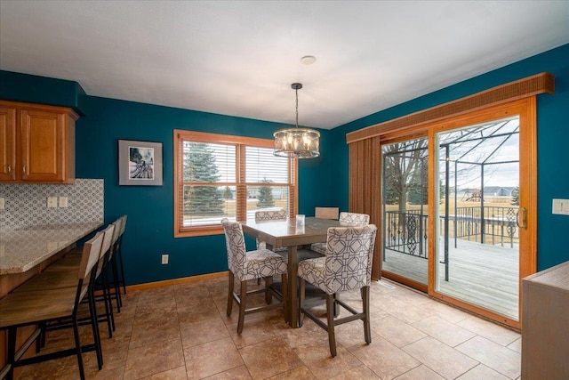 dining space with baseboards and a chandelier