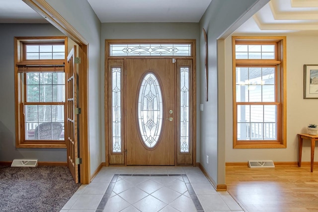 entrance foyer with light tile patterned flooring, visible vents, and baseboards