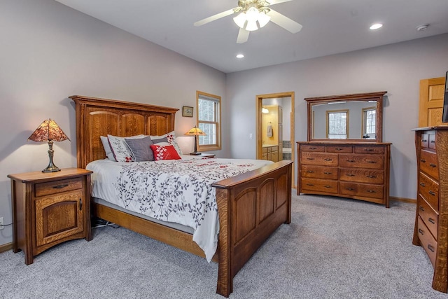 bedroom with recessed lighting, light colored carpet, ceiling fan, and ensuite bath