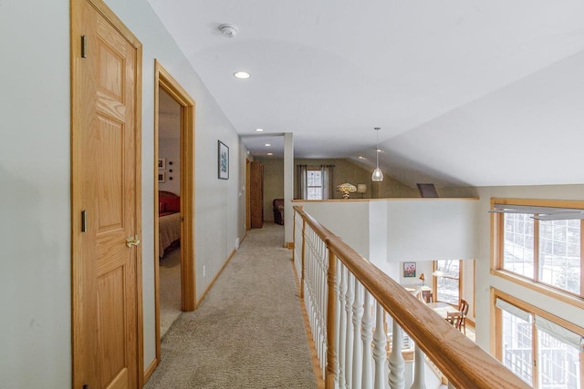 hall featuring lofted ceiling, recessed lighting, an upstairs landing, and light colored carpet