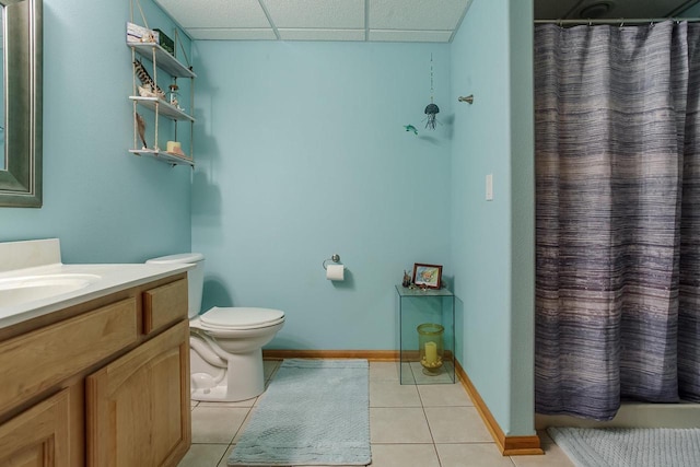 bathroom with curtained shower, toilet, vanity, a drop ceiling, and tile patterned floors