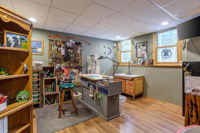 rec room featuring a paneled ceiling, baseboards, and wood finished floors