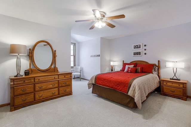 bedroom with light carpet, ceiling fan, and baseboards