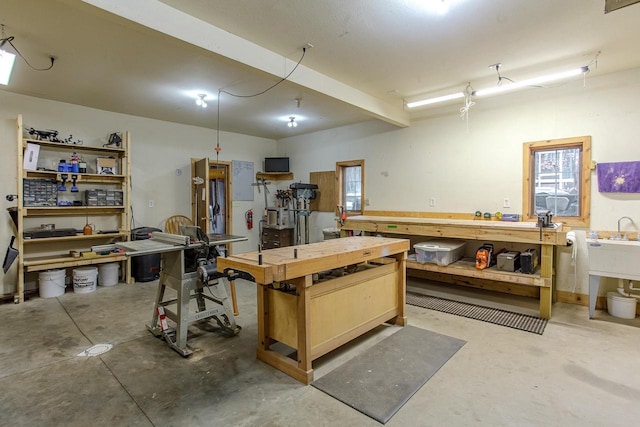 miscellaneous room with unfinished concrete flooring and a workshop area