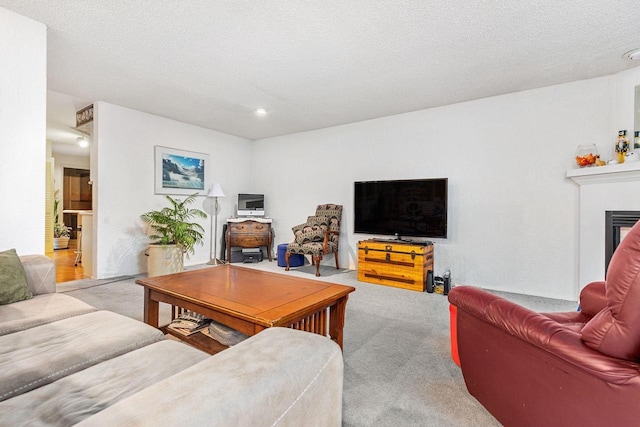 carpeted living area featuring a fireplace and a textured ceiling