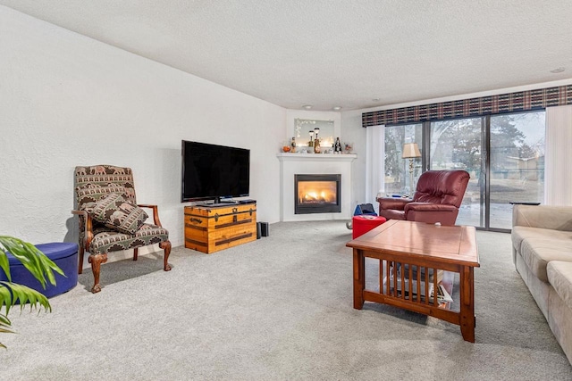 living room with carpet floors, a lit fireplace, a textured ceiling, and a textured wall