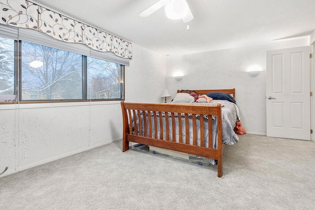 bedroom with a textured wall, carpet floors, and a textured ceiling