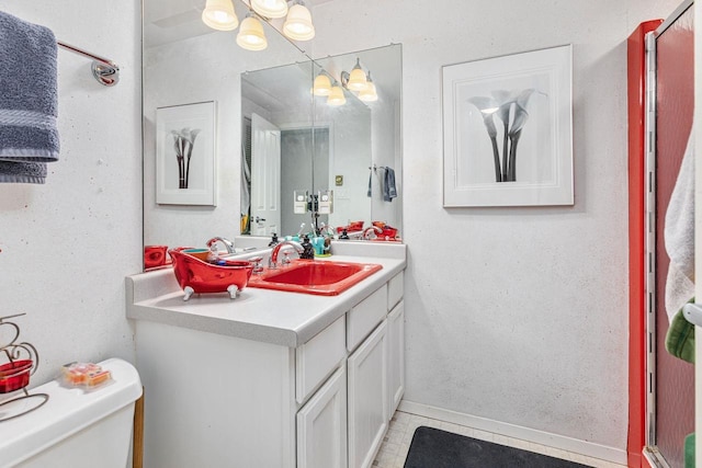 bathroom with toilet, baseboards, vanity, and tile patterned floors