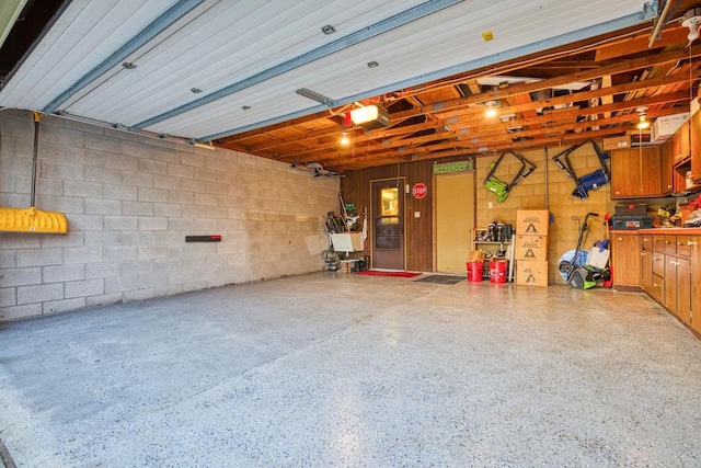 garage with concrete block wall and a garage door opener