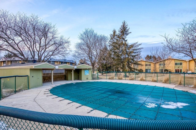 community pool with a patio area and fence