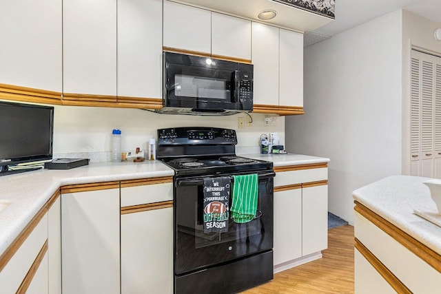 kitchen with white cabinets, black appliances, light countertops, and light wood finished floors