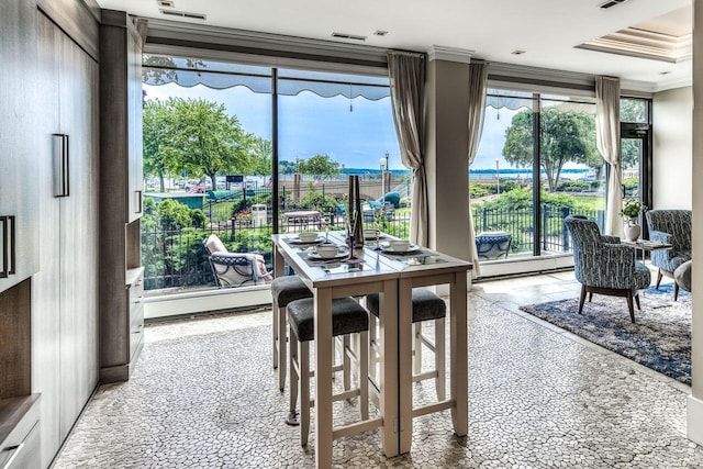 dining area with a wealth of natural light, visible vents, and crown molding