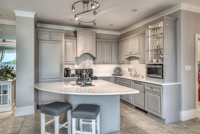 kitchen with appliances with stainless steel finishes, a kitchen breakfast bar, custom exhaust hood, and gray cabinetry