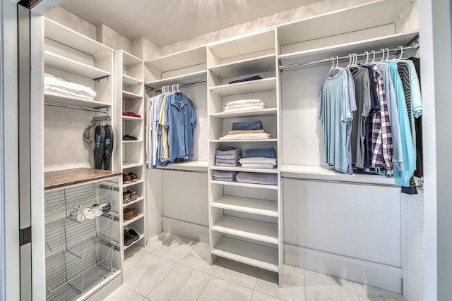 walk in closet with light tile patterned floors