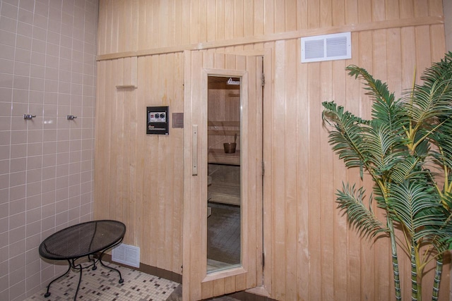 bathroom featuring wood walls and visible vents